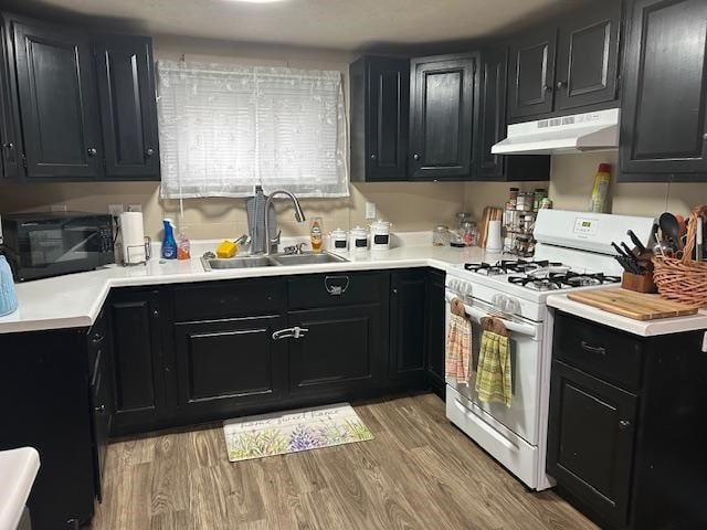 kitchen featuring sink, white range with gas stovetop, and light hardwood / wood-style flooring