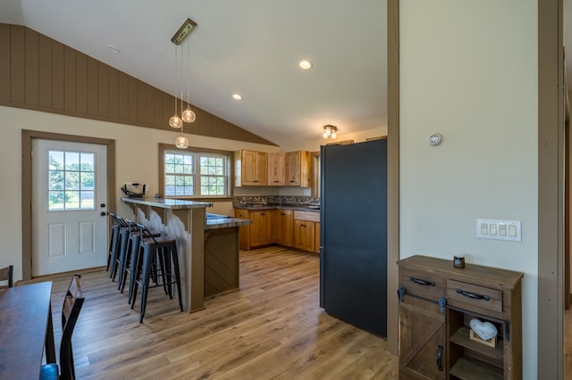 481 Case Rd, Sayre, PA 18840 - kitchen featuring freestanding refrigerator, vaulted ceiling, a peninsula, a breakfast bar, and light wood-type flooring
