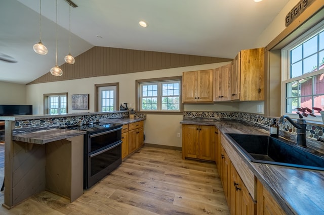 481 Case Rd, Sayre, PA 18840 - kitchen with dark countertops, vaulted ceiling, light wood-style floors, brown cabinetry, and a peninsula