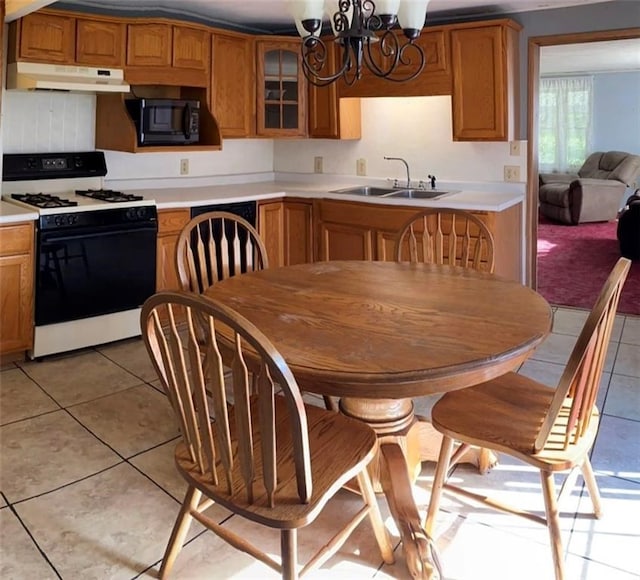 12655 Berwick Tpke, Gillett, PA 16925 - kitchen with white range with gas stovetop, black microwave, under cabinet range hood, light tile patterned flooring, and light countertops