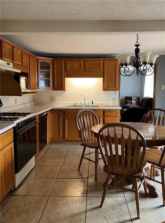 12655 Berwick Tpke, Gillett, PA 16925 - kitchen with gas range, under cabinet range hood, black dishwasher, a textured ceiling, and light countertops