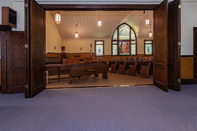 game room with a wainscoted wall, carpet floors, wooden walls, and vaulted ceiling