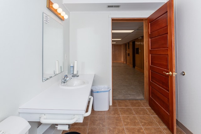 bathroom with visible vents, a sink, tile patterned flooring, crown molding, and toilet