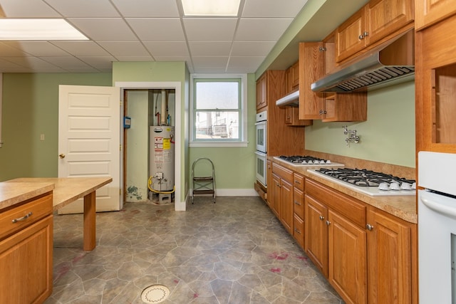 kitchen with under cabinet range hood, gas water heater, white appliances, and light countertops