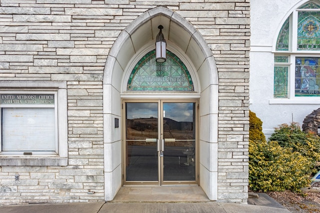 view of exterior entry with french doors and stone siding