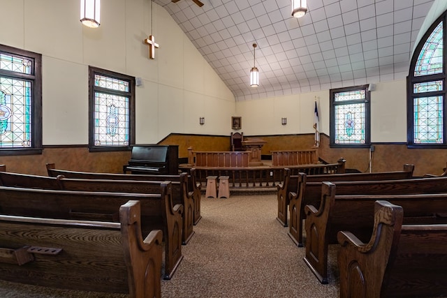 misc room featuring a wainscoted wall, high vaulted ceiling, wood walls, and carpet flooring