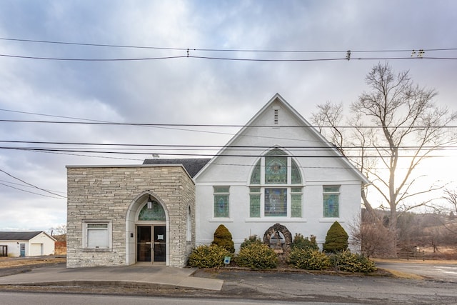 view of front of house featuring stone siding and stucco siding