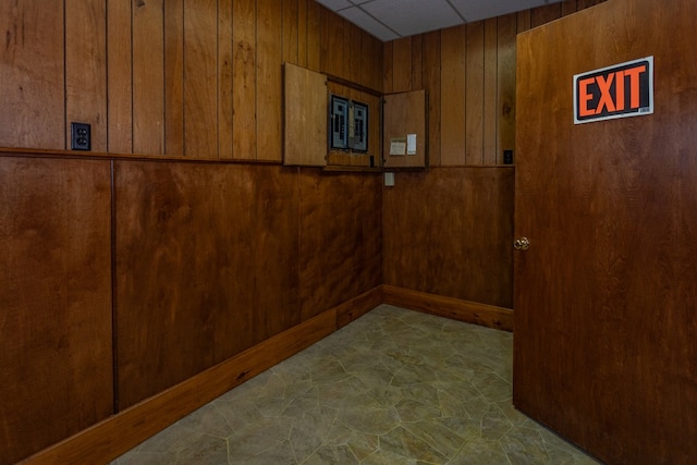 room details featuring a paneled ceiling and wood walls