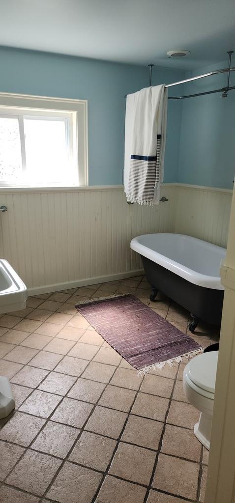 30 S Academy St, Mansfield, PA 16933 - full bathroom with wooden walls, toilet, a freestanding bath, and a wainscoted wall