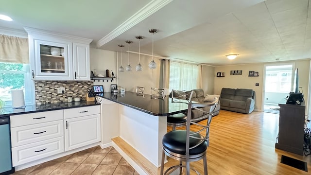 106 Magnolia St, Athens, PA 18810 - kitchen featuring a peninsula, a breakfast bar area, dark countertops, open floor plan, and white cabinetry