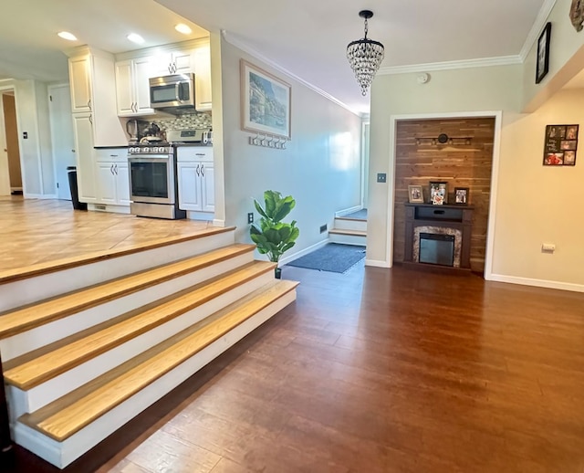 106 Magnolia St, Athens, PA 18810 - living room with stairway, wood finished floors, a chandelier, ornamental molding, and a glass covered fireplace
