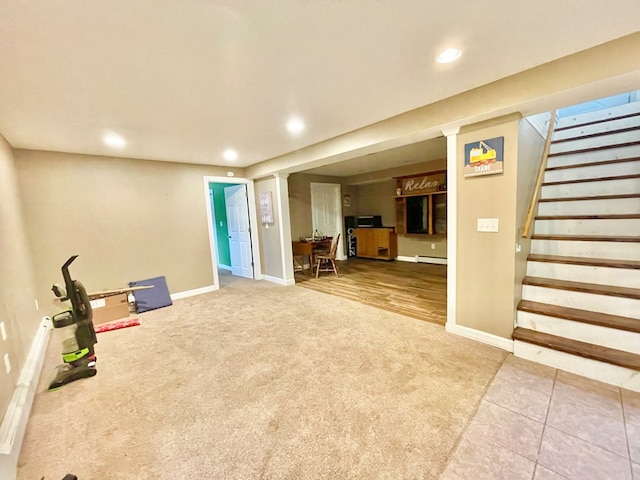 basement featuring a baseboard heating unit and carpet floors