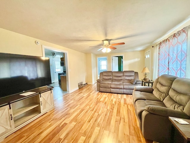 living room with ceiling fan and light wood-type flooring