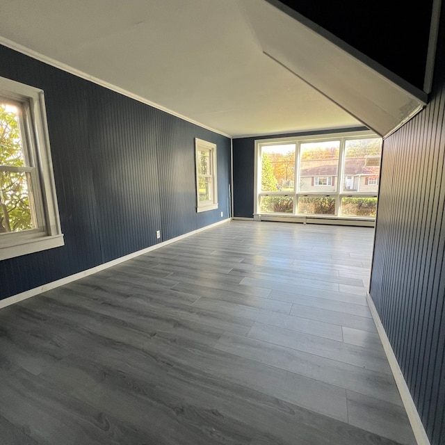 empty room with hardwood / wood-style floors and crown molding