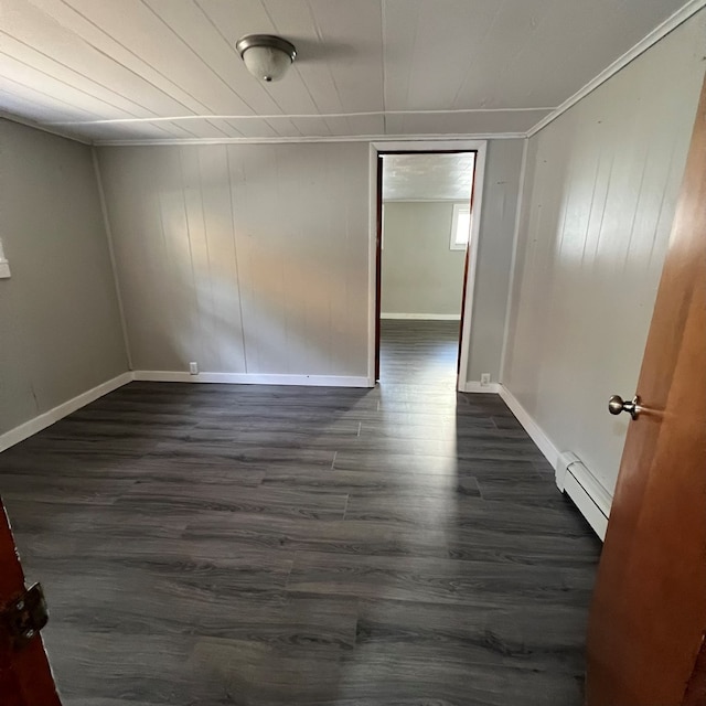 unfurnished room featuring dark hardwood / wood-style floors and baseboard heating