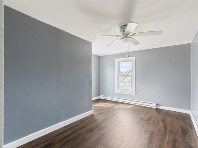 unfurnished room featuring ceiling fan, dark hardwood / wood-style flooring, and a baseboard heating unit