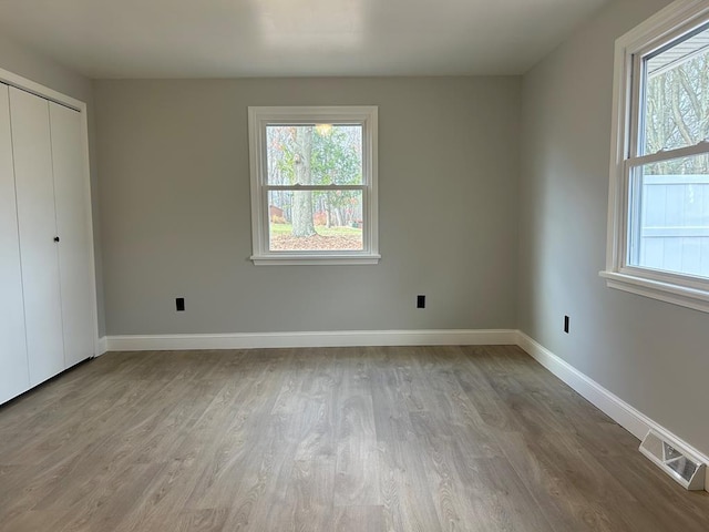 unfurnished bedroom featuring a closet and light wood-type flooring