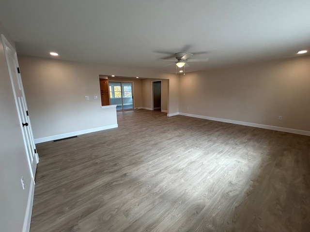 unfurnished living room featuring dark hardwood / wood-style floors and ceiling fan