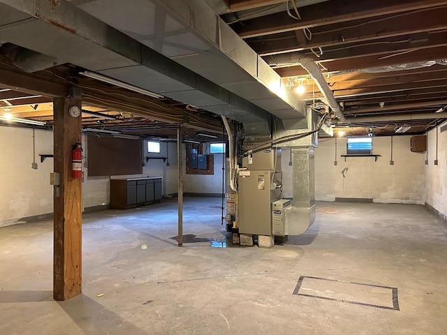 basement featuring electric panel and heating unit