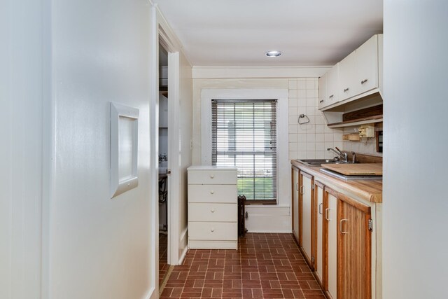 213 Holden St, Osceola, PA 16942 - kitchen with brick patterned flooring, a sink, and white cabinetry