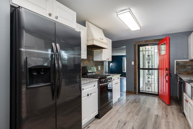 213 Holden St, Osceola, PA 16942 - kitchen featuring black refrigerator with ice dispenser, range with gas stovetop, backsplash, and white cabinets