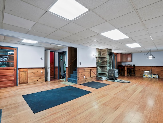 3046 Old Plank Rd, Towanda, PA 18848 - exercise room with a wood stove, hardwood / wood-style flooring, wood walls, wainscoting, and a paneled ceiling