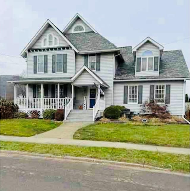 view of front facade with a front yard and covered porch