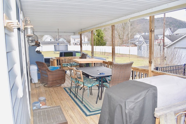 wooden terrace featuring grilling area, a storage unit, and a mountain view