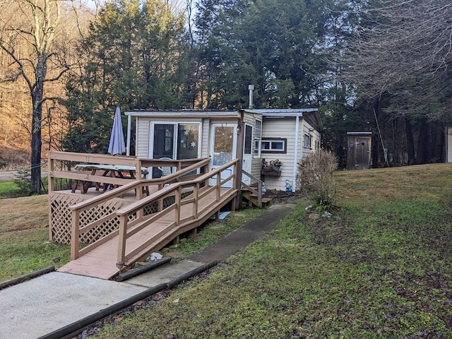 view of front of property with a deck and a front lawn