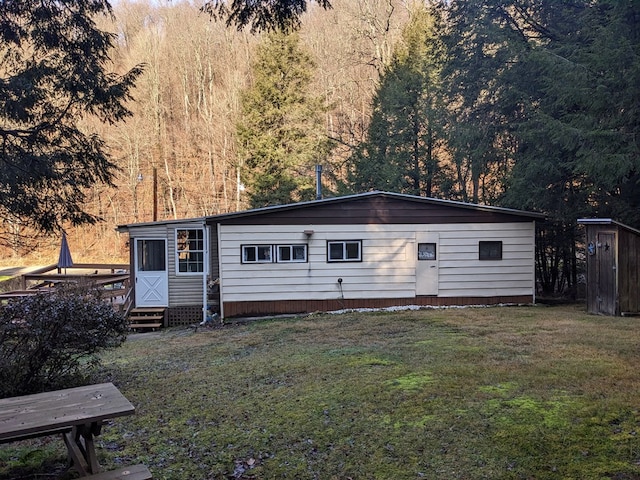 rear view of house with a yard and a wooden deck