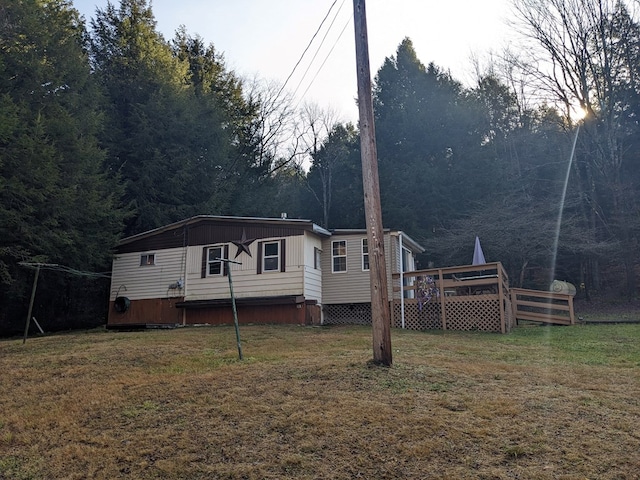 rear view of house with a lawn and a wooden deck