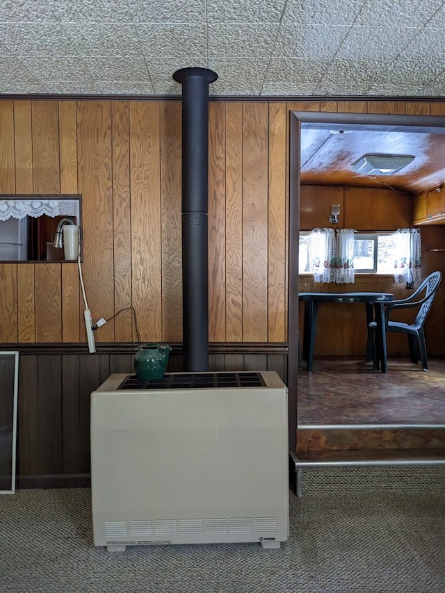 details with carpet floors, a wood stove, and wood walls