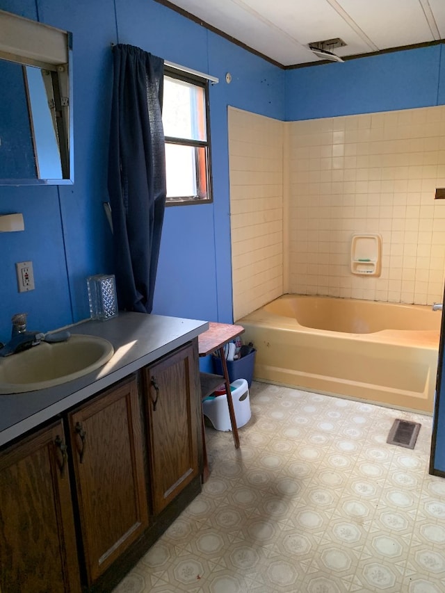 bathroom featuring vanity and tiled shower / bath