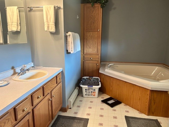 bathroom with a washtub and vanity