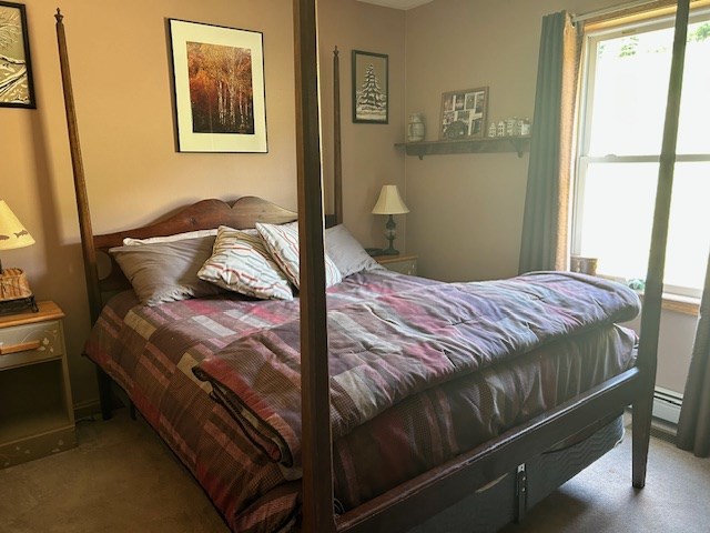 carpeted bedroom featuring a baseboard radiator