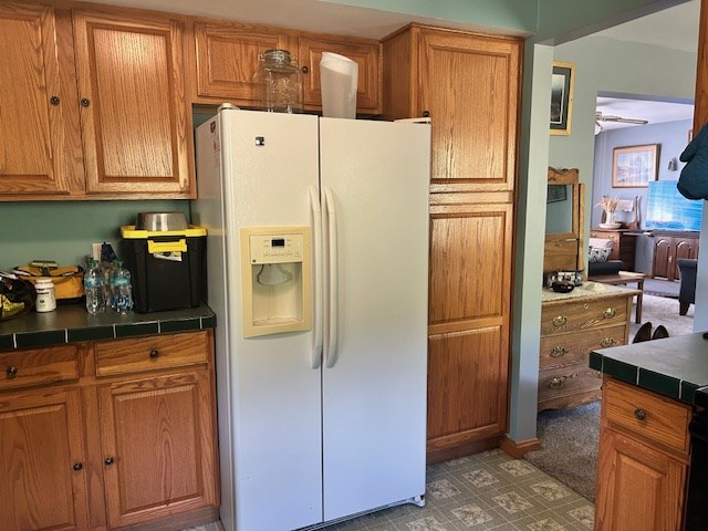 kitchen with ceiling fan and white refrigerator with ice dispenser