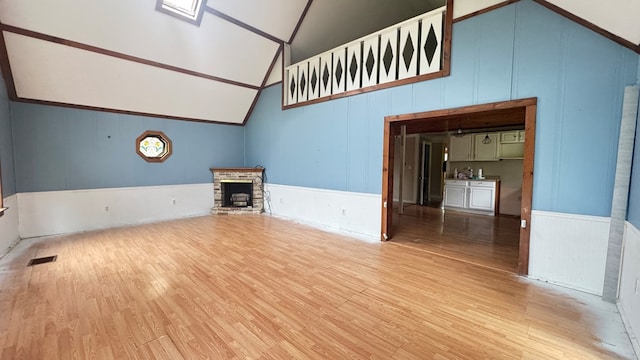 8380 Sheshequin Rd, Athens, PA 18810 - unfurnished living room featuring wood finished floors, a fireplace with raised hearth, high vaulted ceiling, and wainscoting