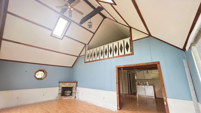 8380 Sheshequin Rd, Athens, PA 18810 - unfurnished living room featuring wood finished floors, lofted ceiling, a ceiling fan, a brick fireplace, and plenty of natural light