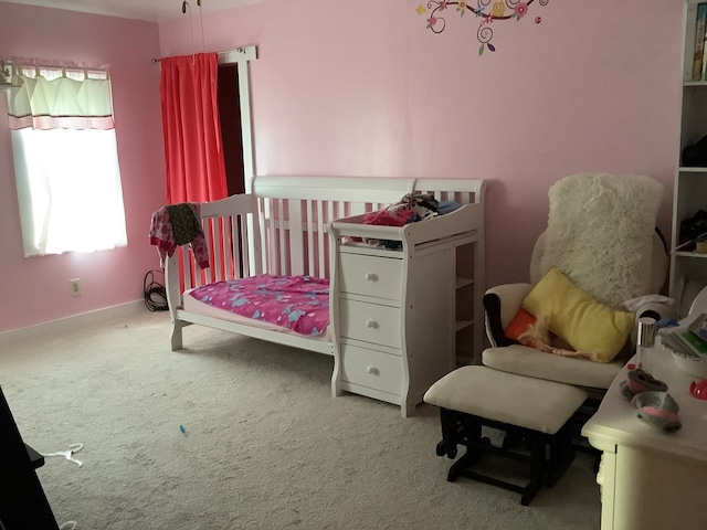 bedroom with light carpet and a crib