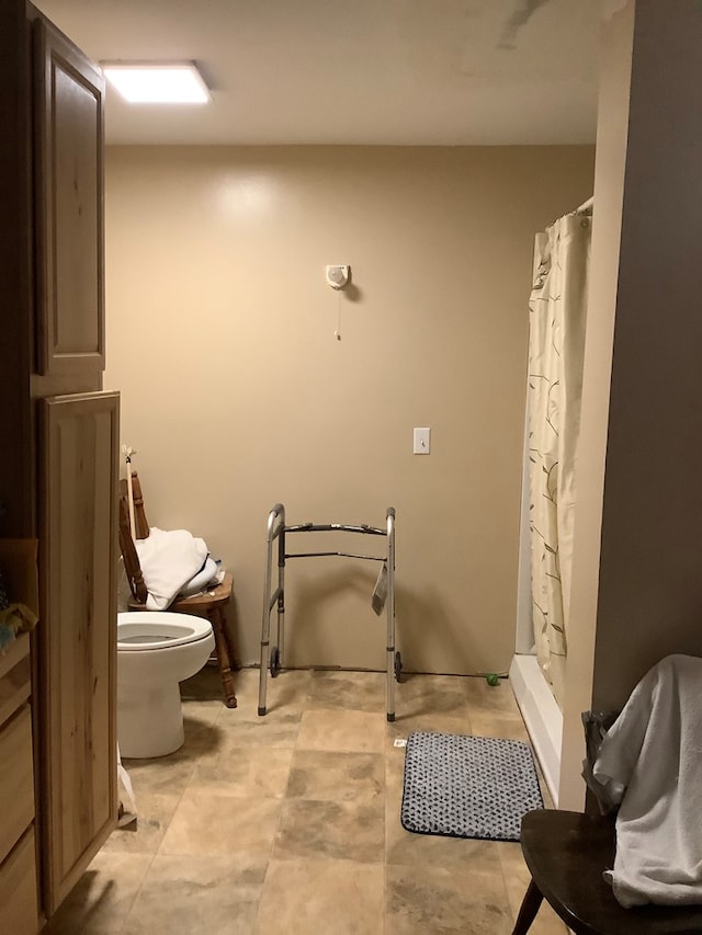 bathroom featuring curtained shower and toilet