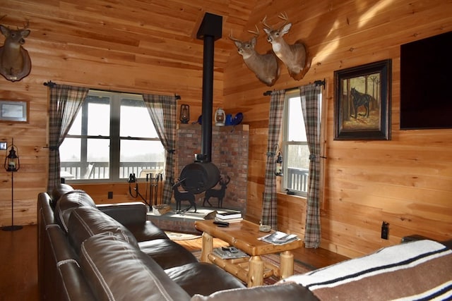 living room featuring a wood stove and wood walls