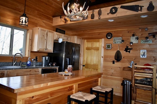 kitchen with butcher block counters, wooden ceiling, pendant lighting, wooden walls, and black appliances