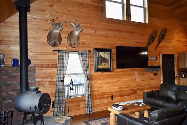 living room featuring a wood stove and wooden walls