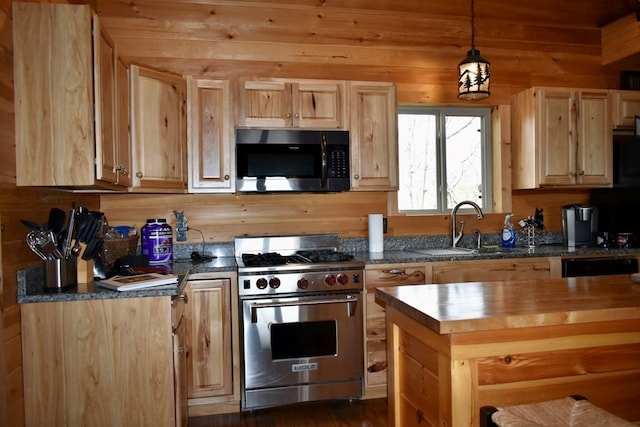 kitchen with dark stone counters, wooden walls, light brown cabinets, decorative light fixtures, and premium stove