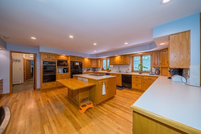 105 Laurel Ln, Sayre, PA 18840 - kitchen with black appliances, light countertops, a baseboard radiator, a center island, and a sink