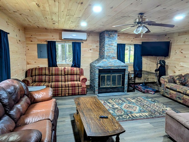 198 Spring Run Rd, Smethport, PA 16749 - living room featuring a wall mounted air conditioner, wood walls, a ceiling fan, wood finished floors, and wood ceiling