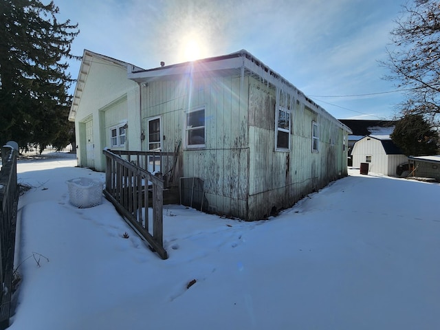 snow covered property featuring a shed