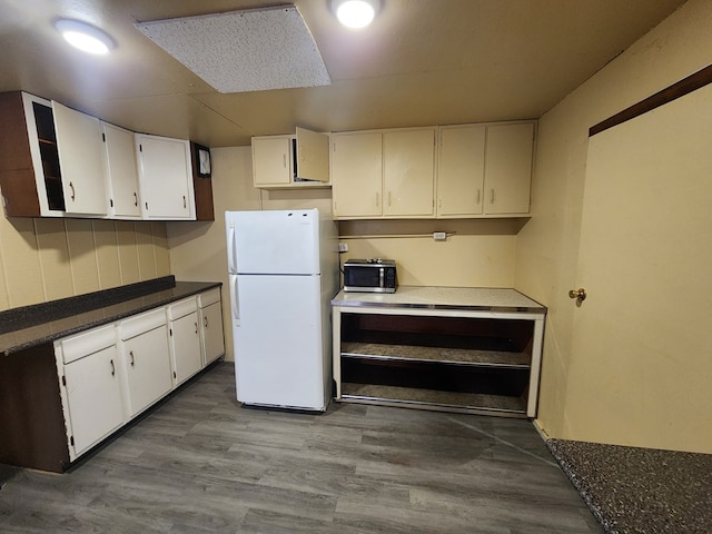 kitchen featuring white cabinetry, light hardwood / wood-style flooring, and white refrigerator