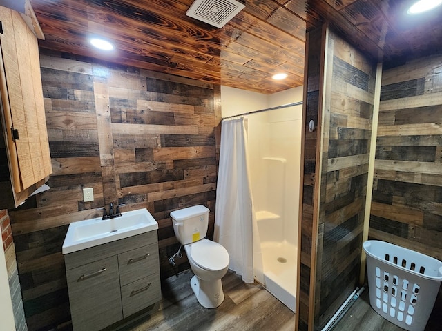 bathroom with wooden walls, vanity, walk in shower, toilet, and wooden ceiling