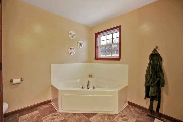 bathroom with toilet and a bathing tub